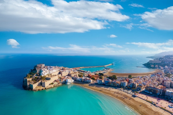Luxury yacht charter in Spain with a stunning view of the Mediterranean Sea, vibrant coastal landscapes, and a serene sunset horizon.