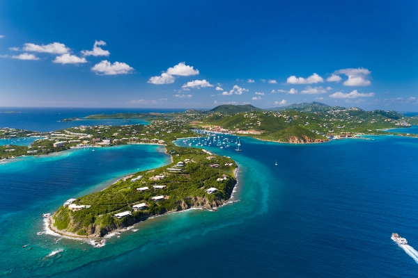 Aerial view of a yacht charter in the U.S. Virgin Islands near St. Thomas, surrounded by crystal-clear waters and lush green hills.