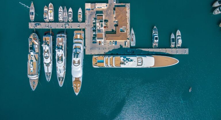 Boats docked at a harbor. Discover yacht management services: maximize income, ensure tax compliance, and streamline provisioning for stress-free yacht ownership.