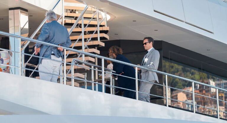 Corporate men enjoying their corporate yacht charter and standing on a luxury yacht. Experience ultimate luxury with a corporate yacht charter. Tailor your event on a private yacht for unforgettable, exclusive experiences.