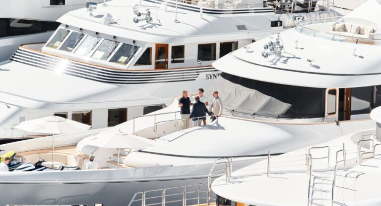 A professional yacht broker talking with a group of potential yacht buyers to sell a luxury yacht. Selling yachts with a trusted broker. Learn how much yacht brokers make and how to sell your yacht or boat successfully.