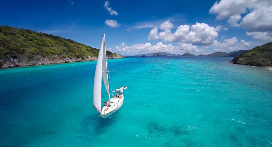 A catamaran or a monohull sailing in the ocean. Compare catamarans vs monohulls to find the best fit for your sailing style. Learn about cost, speed, stability, and more.