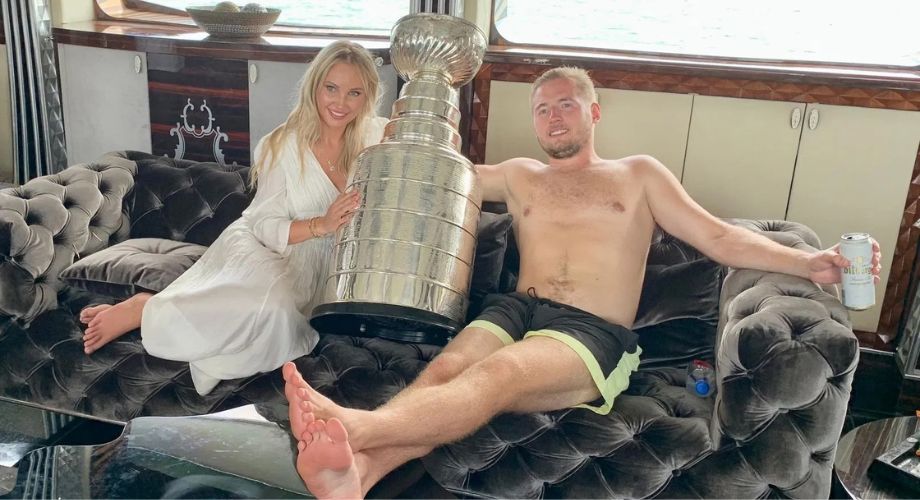 A couple sitting on a sofa and pausing for a photo with a big trophy between them. With the Florida Panthers winning back-to-back Stanley Cup titles, YATCO looks back at how the team celebrated 2024 victory on water.