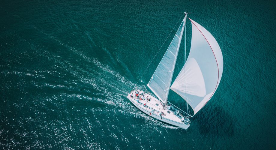 A sailboat sailing in the ocean. Explore sailboat autopilot systems, including installation costs, and how autopilots improve your sailing experience.
