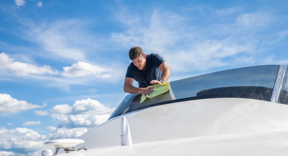 A man cleaning a yacht's window.