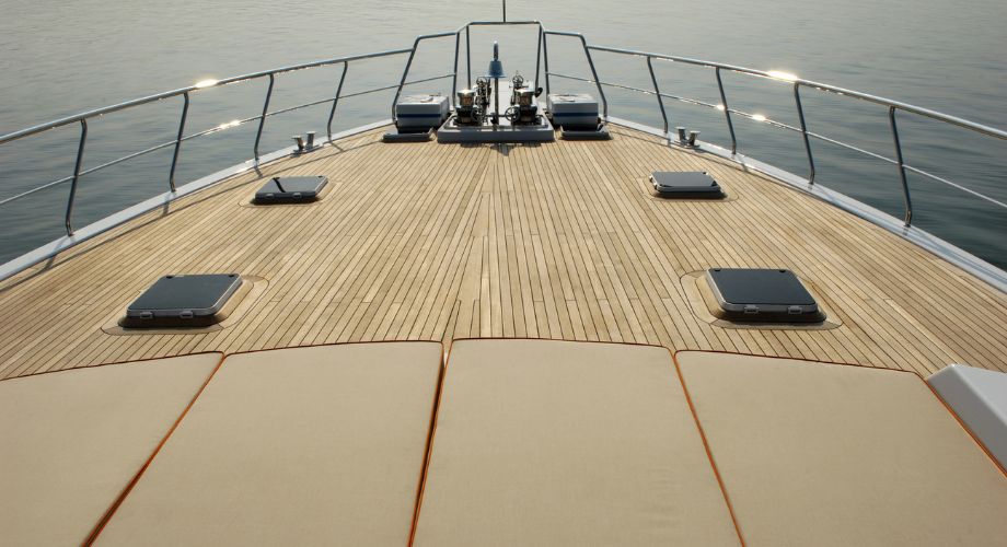 An outdoor wooden yacht deck of a yacht sailing in the ocean.