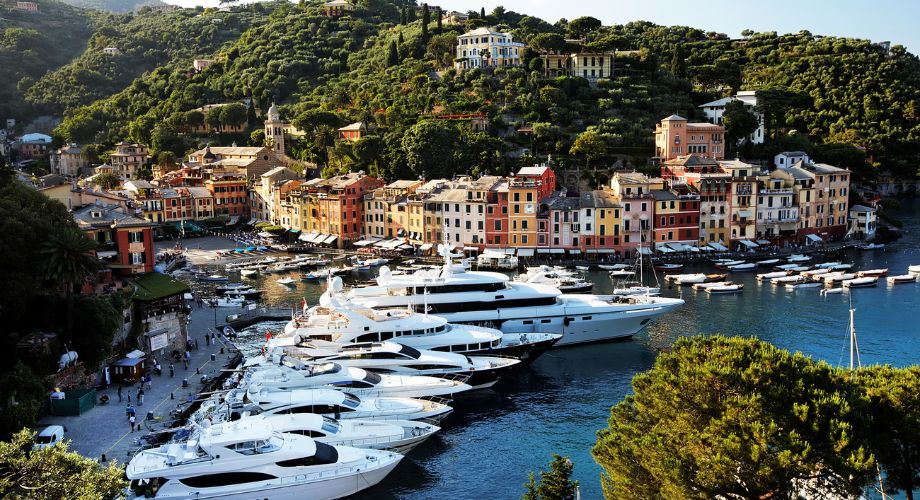 A wide range of yachts docked in the ocean near an island. Understand yacht depreciation rates, resale value, and how much boats depreciate yearly. Learn how to buy smart.