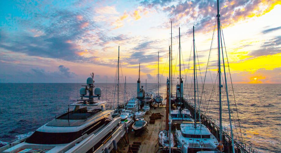Yachts docked in the marina ready for their yacht transport journey. Need yacht transport? Learn how to ship a boat, compare transport costs & find reliable yacht transport companies for timely delivery.