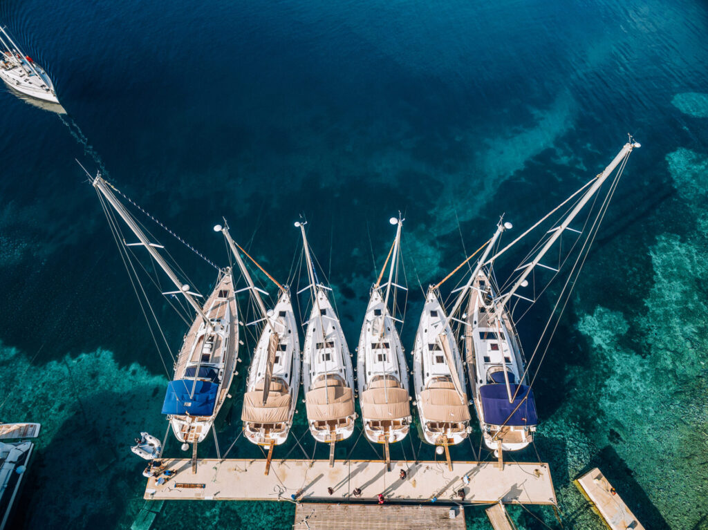 Six yachts docked in a Croatian ocean marina.