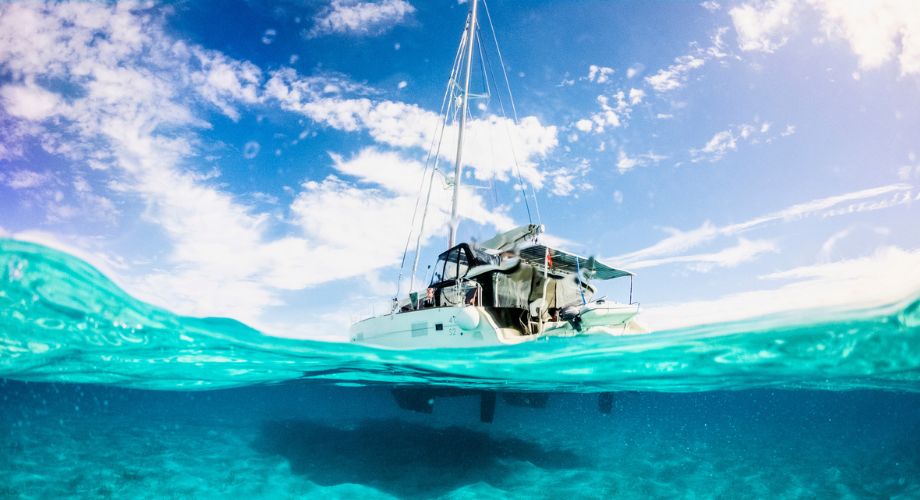 An eco-friendly catamaran sailing in the ocean. Discover how the YETI index is shaping eco-friendly yacht standards and encouraging sustainable practices in the yachting industry.