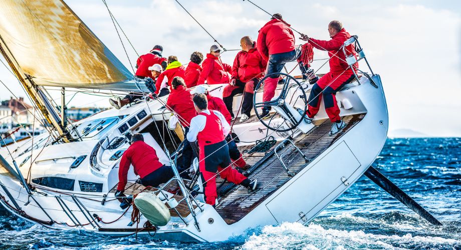 A group of people on a sailing yacht that's sailing in the ocean.