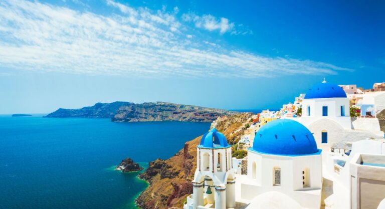 A stunning view of Santorini, Greece, showcasing its iconic white-washed buildings with blue domes perched on cliffs overlooking the deep blue Aegean Sea. Explore the top 10 largest yachts for charter in the Mediterranean—featuring luxury vessels in a range of sizes with standout amenities.