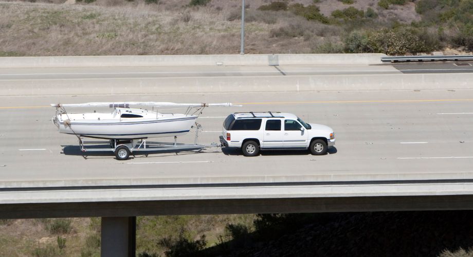 A yacht delivery car delivering a yacht on a highway.