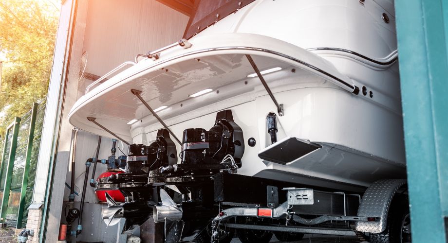 A powerboat is seen in a maintenance facility, securely positioned on a trailer—ready for land transport or local yacht delivery.