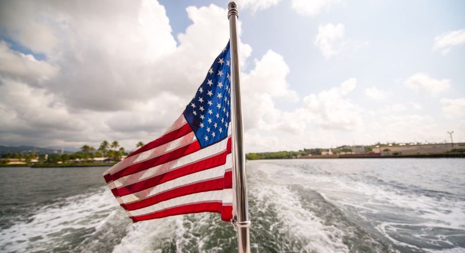 The U.S.A. yacht registration flag is flying on a yacht sailing in the ocean.