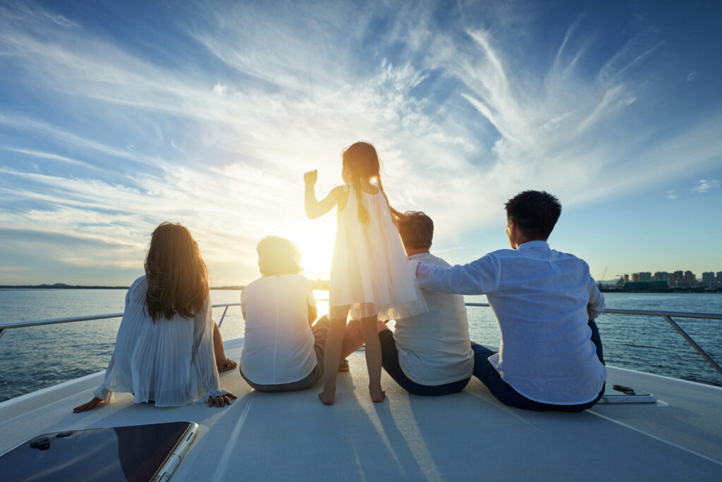 Happy family aboard one of the family cruisers out at sea. Explore the best family cruisers, from small yachts to sailboats, for safe, comfortable, and fun trips at sea.