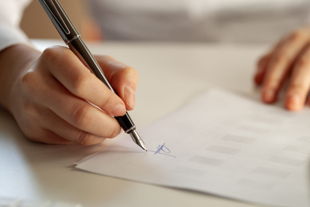 Yacht Charter License | Legal Requirements | Regulations | YATCO A man signing a yacht charter license contract.