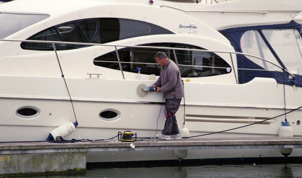 Yacht Detailing | Guide To Services, Costs & Expert Tips | YATCO A man cleaning an expensive boat. Discover yacht detailing services, costs, and expert tips to keep your vessel spotless inside and out, all year round.