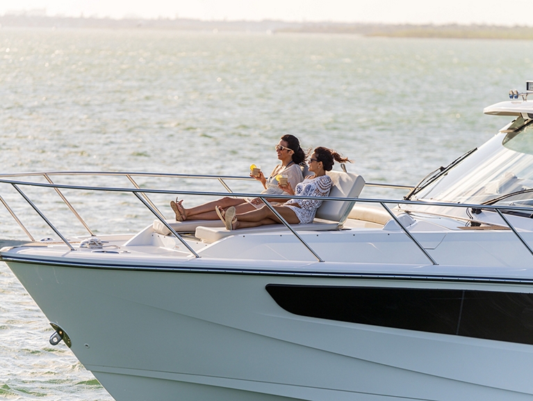 Boston Whaler Yachts | Models and Motorboats | YATCO A couple sailing on the ocean in a Boston Whaler 405 Conquest Navico 28.
