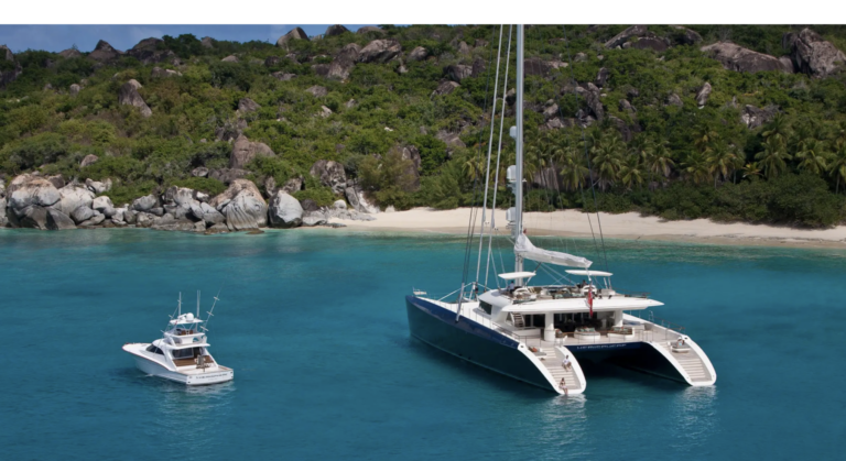 Two catamarans are sailing on the ocean. Explore the top 10 largest catamarans for sale, from 150-foot support vessels to 115-foot sailing icons. Discover elite multihull design.