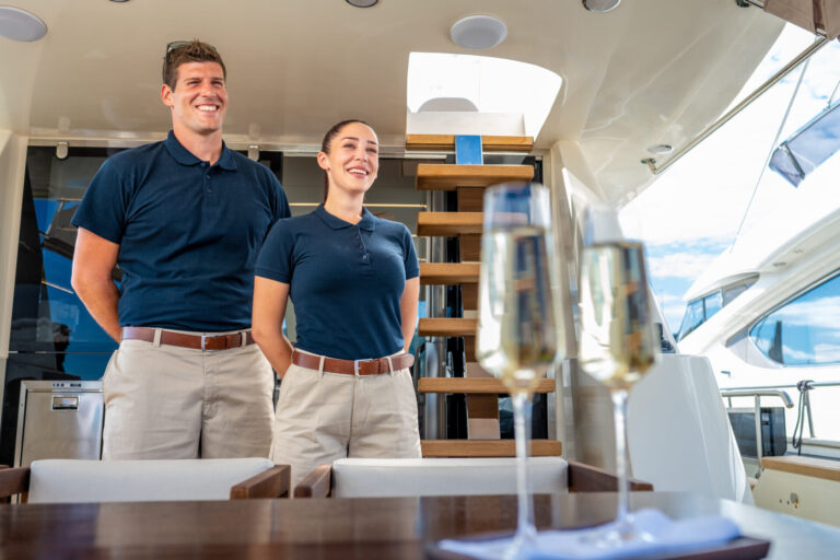 Smiling skipper and stewardess standing in luxury yacht. Triton grows globally with a crew-first focus, digital expansion, and new ways to connect captains, crew, and the wider yachting community.