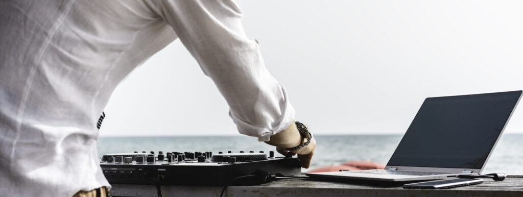 Yacht Entertainment Systems | Tech & Party Features | YATCO Disc jockey playing music for tourist people at club party with yacht entertainment systems.