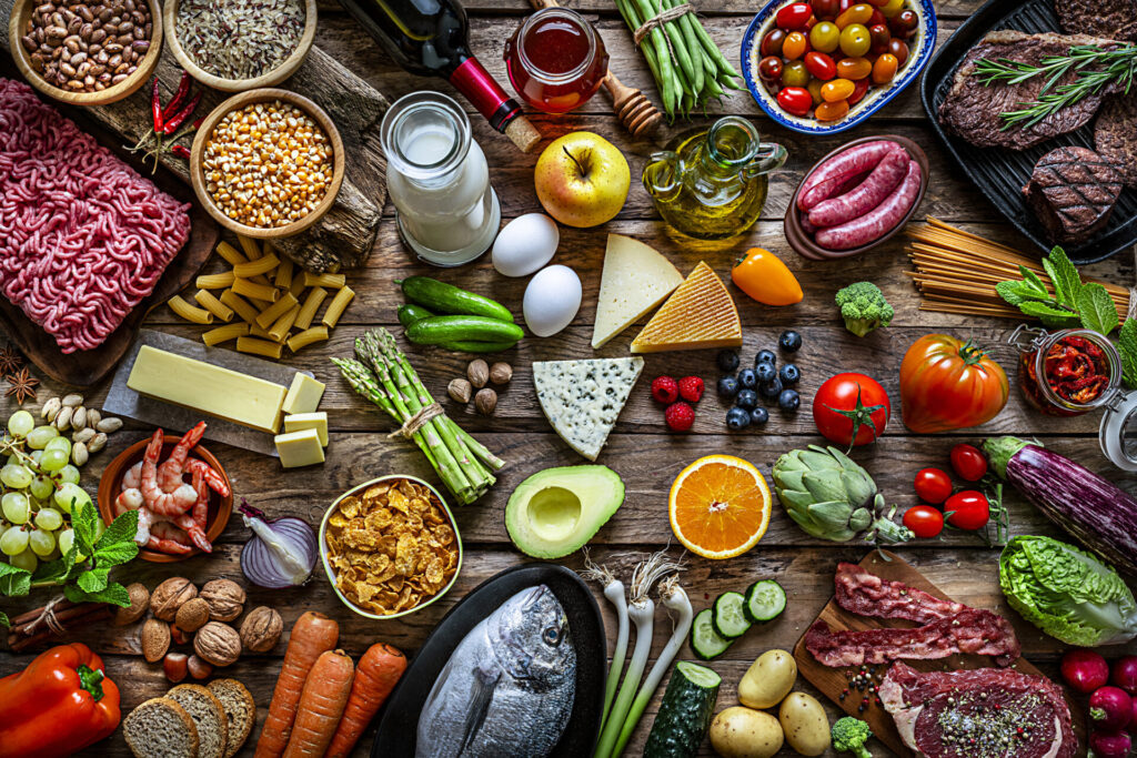 Yacht Provisioning | Guide to Services & Global Suppliers | YATCO Food and drink backgrounds: top view of a wooden table filled with a large variety of food. Learn all about yacht provisioning, from essentials and storage tips to top global suppliers and charter services.