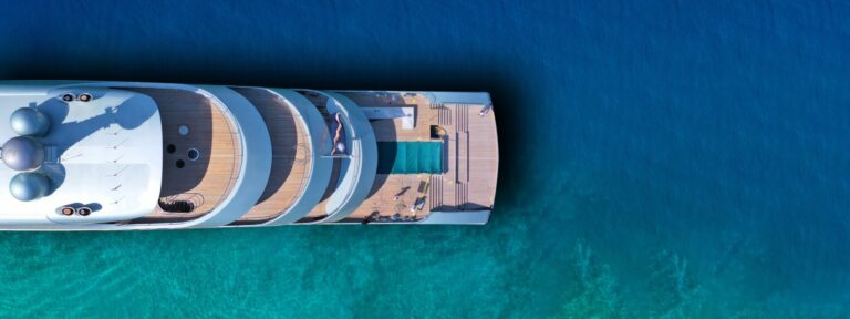 A luxury yacht is sailing on the ocean. Explore how the value of a yacht affects ongoing maintenance & insurance costs. Explore depreciation & insights into the luxury yacht market.