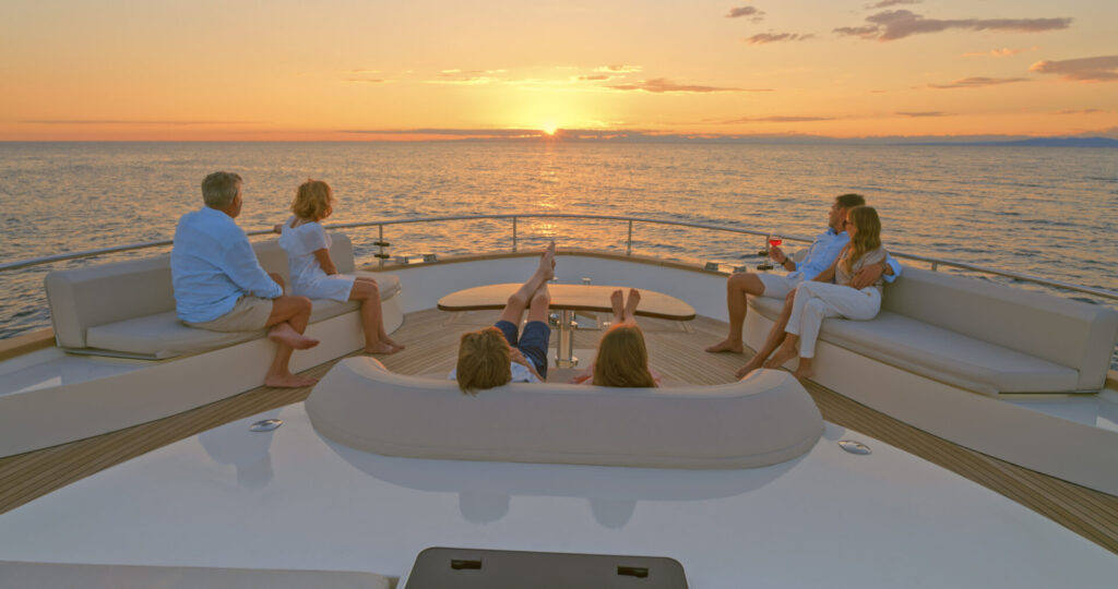 Family looking at view while sitting on sofa in luxury yacht. Discover how the yachting industry adapted, pivoted, and thrived post-COVID, building resilience through innovation and agility.