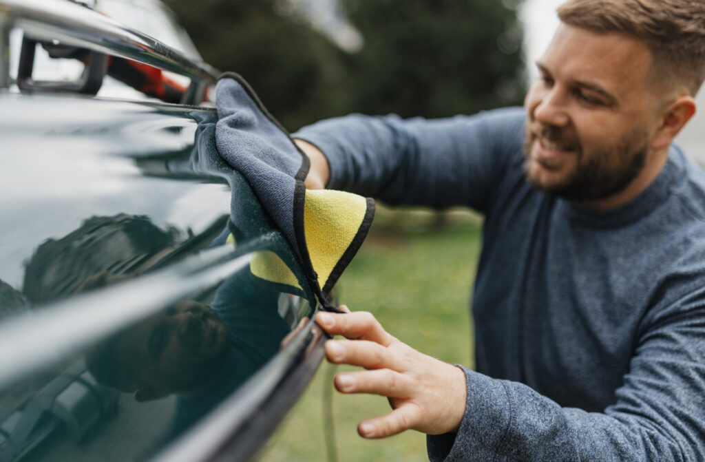 An individual is carefully working on boat maintenance using a rotary buffer, emphasizing the importance of preserving the boat's aesthetics and functionality for enjoyment.