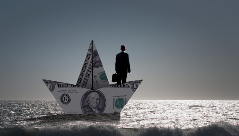 New Economics of yacht ownership. A man standing on a boat made from dollars.
